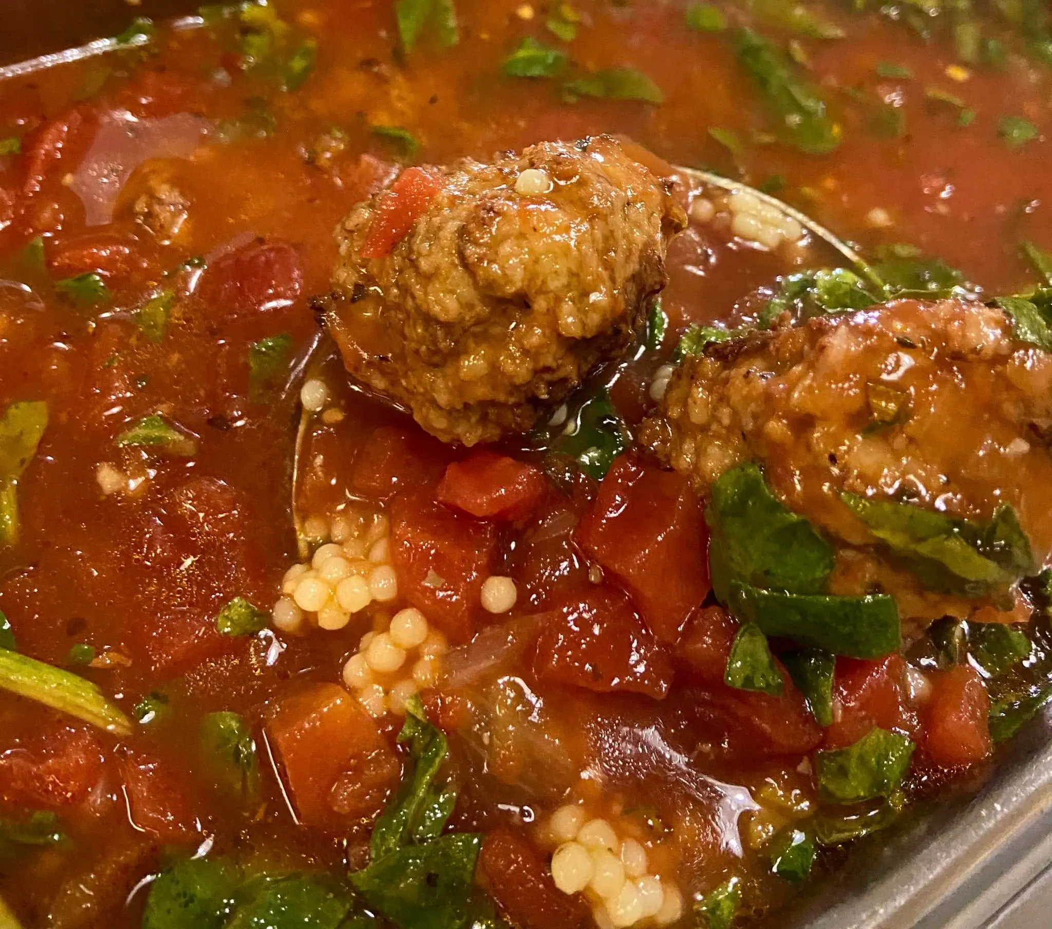 Meatball soup with acini di pepe pasta, spinach and diced tomato