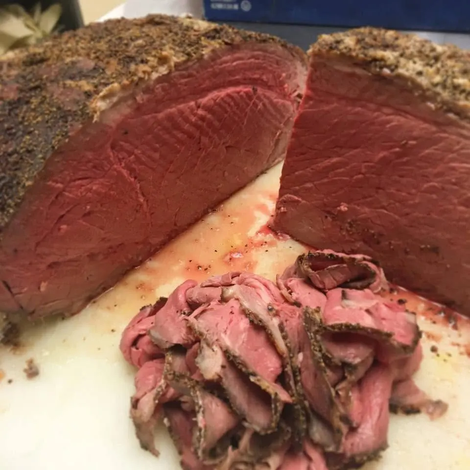 Peppercorn-crusted roast beef, sliced thin, with the roast it was carved from